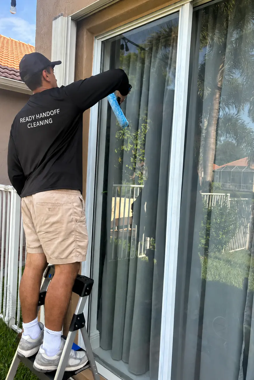 ReadyHandoff Cleaning team member cleaning a window with a squeegee